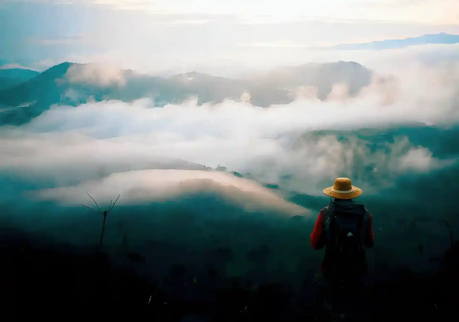 Mountain background with a single hiker in the foreground looking out at the view